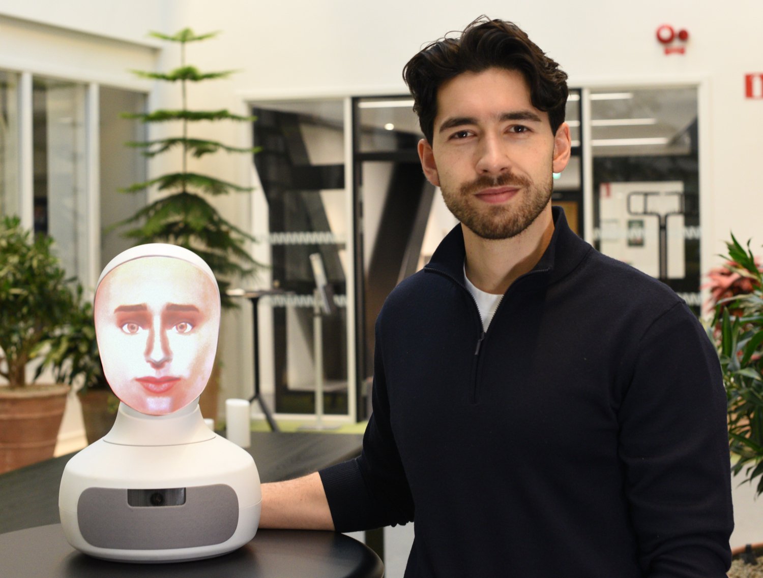 Medical student interviewing the SARI humanoid robot in a clinical simulation room