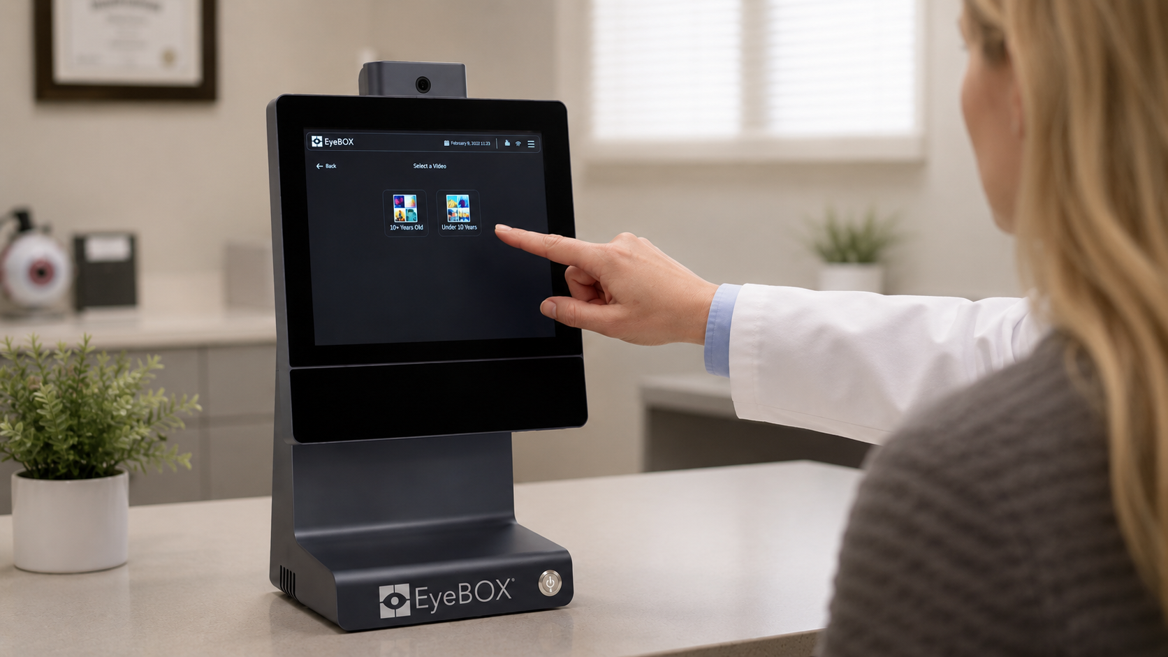 Clinician and patient using the EyeBOX eye-tracking device in a clinical setting