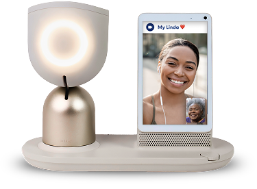 ElliQ companion robot on a tabletop in a warmly lit indoor setting
