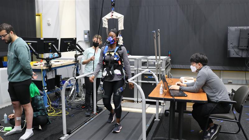 Person wearing a powered hip exoskeleton walking in a Georgia Tech gait laboratory